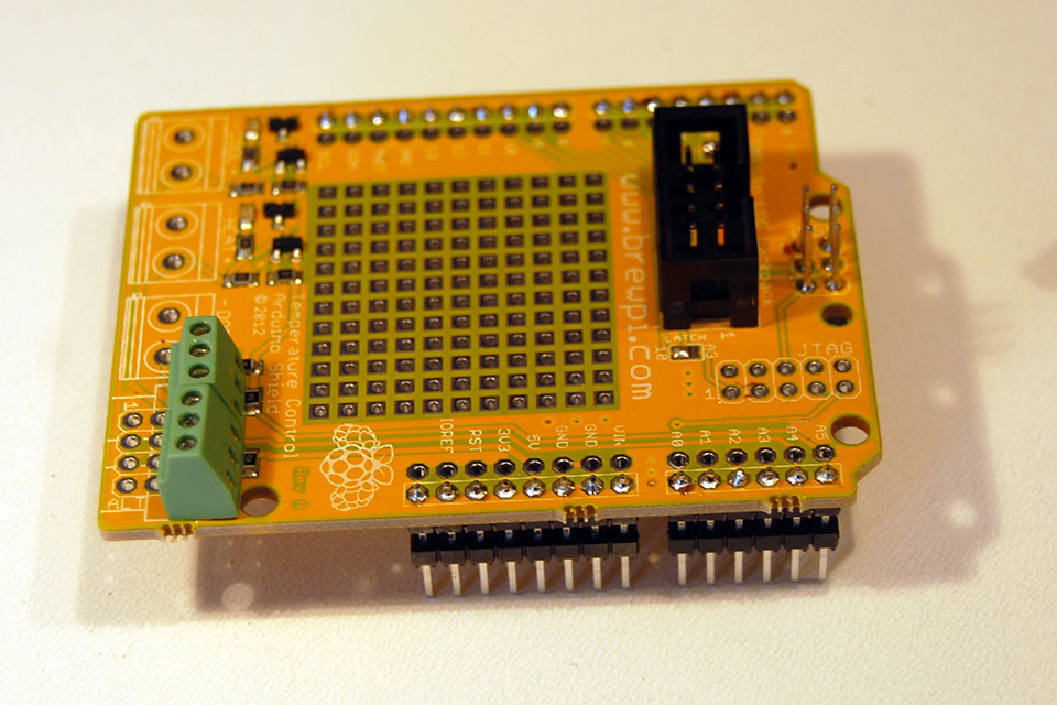Next are the mini screw terminals for the temperature sensors and the 10 pin shrouded IDC header. We will do both at once because they are the same height. Insert them and flip your board over.