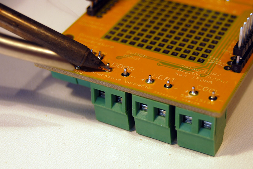 First solder one pin of each connector. Pick the one that is not connected to the ground plane.