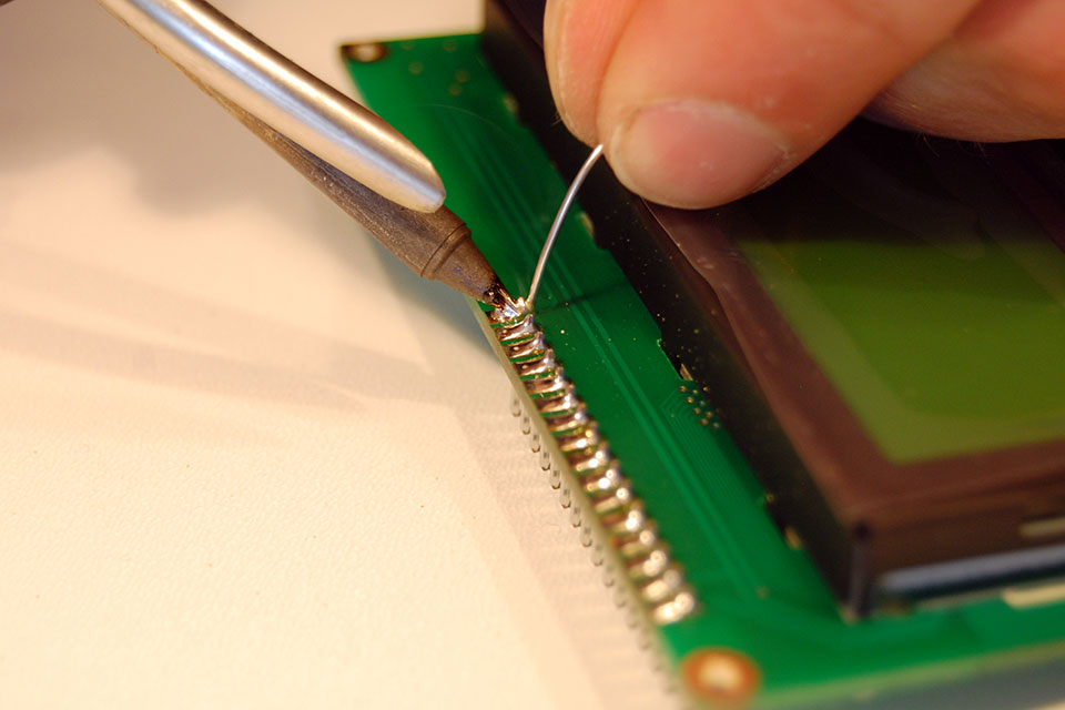Finish soldering the rest of the pins. I get the best result by pressing the tip against the pin and applying solder from the other side. When it flows, drag your tip off the pad.