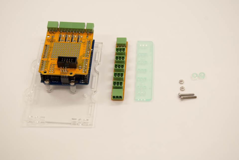 You can mount the OneWire distribution board to the back of the case or mount it somewhere else in the fridge. If you want to mount it to the case, these are the parts you need: OneWire board, Panel to go under the board, 2 laser cut spacers, 2 M2.5x16 bolts and nuts, 2 washers.